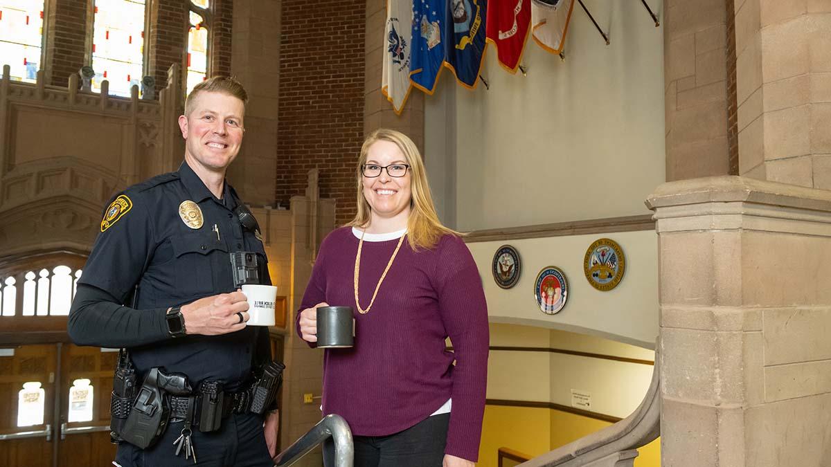 校友和运营教育奖学金获得者Jennifer Tengono和Jason 房子在纪念体育馆的大厅里拿着咖啡杯